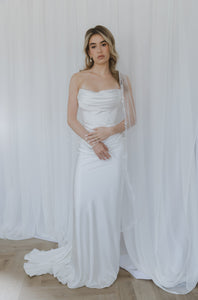 Notable contemporary two-piece wedding look made of lux Italian silk. The corset features a cinched waist and draped neckline inspired by the classic ball gown and a boned corset with a zipline on the back. The corset is doubled, with an additional shaping corset sewn in. The look is finished with a flowy skirt with a midi train reminiscent of ancient Greek statues.