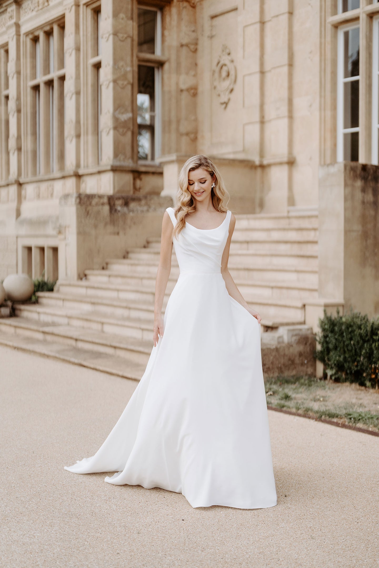 Beautiful Lanesborough has a slightly off the shoulder scooped neckline with a corseted bodice, v-back and a full A-line skirt, in Crepe. 