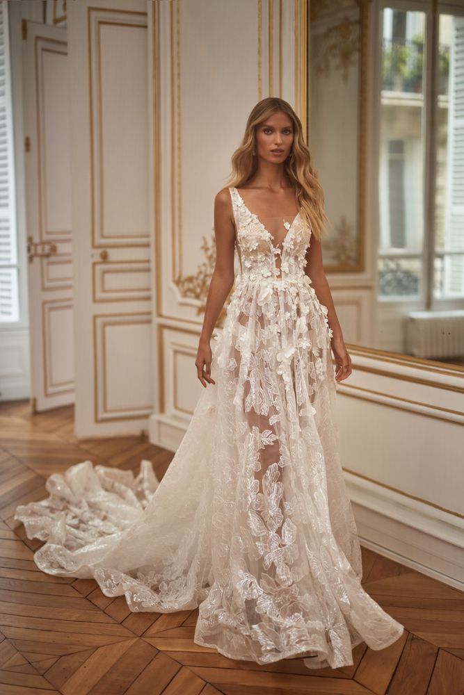 Fairy-like A-line semi-transparent wedding gown on straps with 3D flower lace applique and silver shiny ornament. Featuring a daring illusion plunging neckline, lace-up closure on the back, nude lining skirt, and a train.